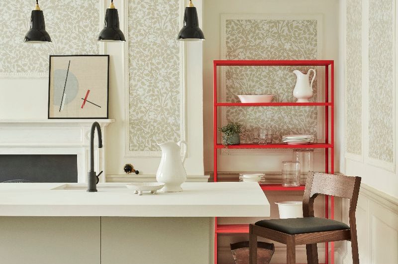 A white, minimalist space with handleless furniture, tall ceilings, and classic panelling.