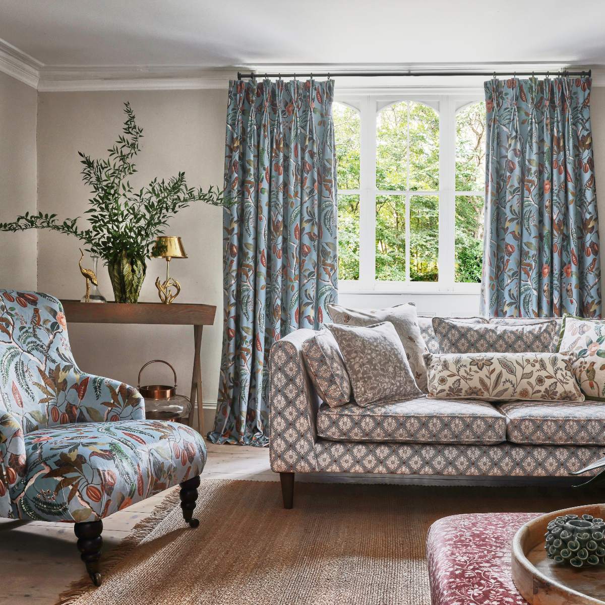 Living room with patterned textiles, a jute rug, and a curved window.