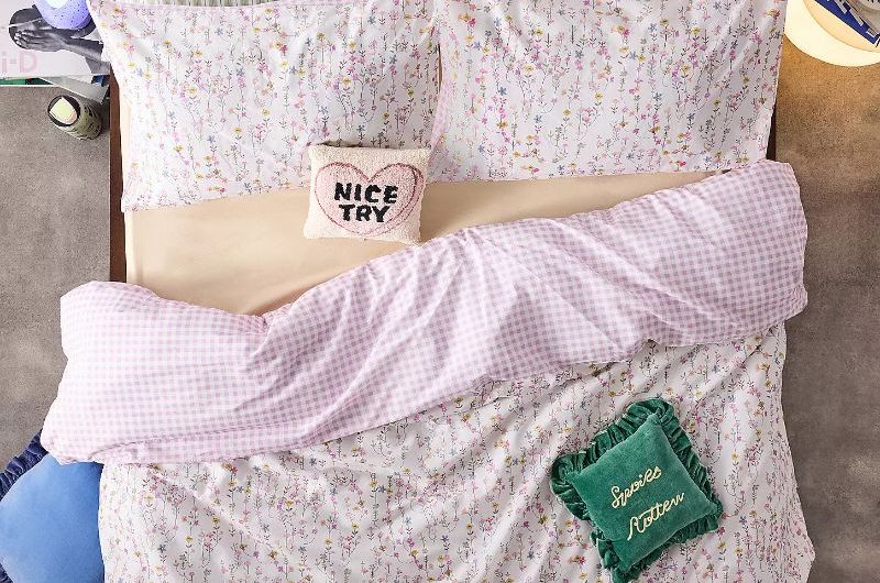 View of a layered bed with reversible duvet, striped pillows and quirky decor.