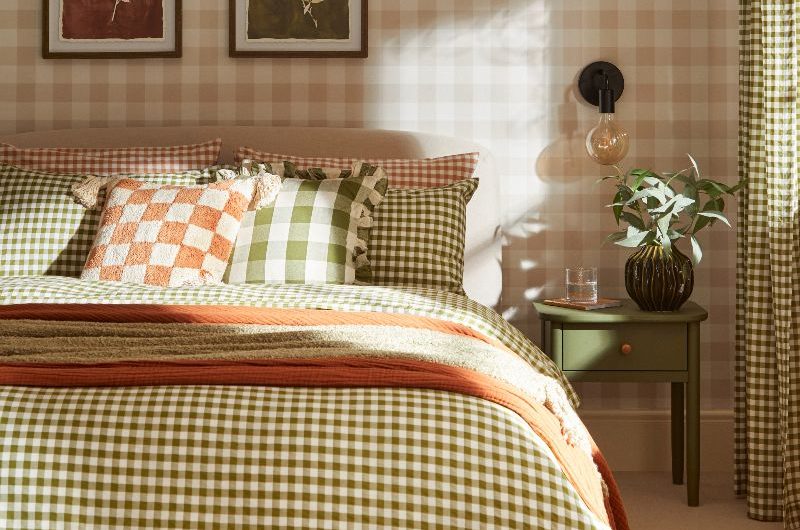 A bedroom drenched in gingham prints, from the bed linen, curtains, to the wallpaper, with timeless decor.
