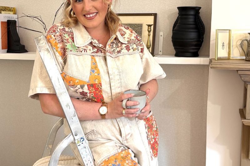Portrait of a renovator posing on a ladder.