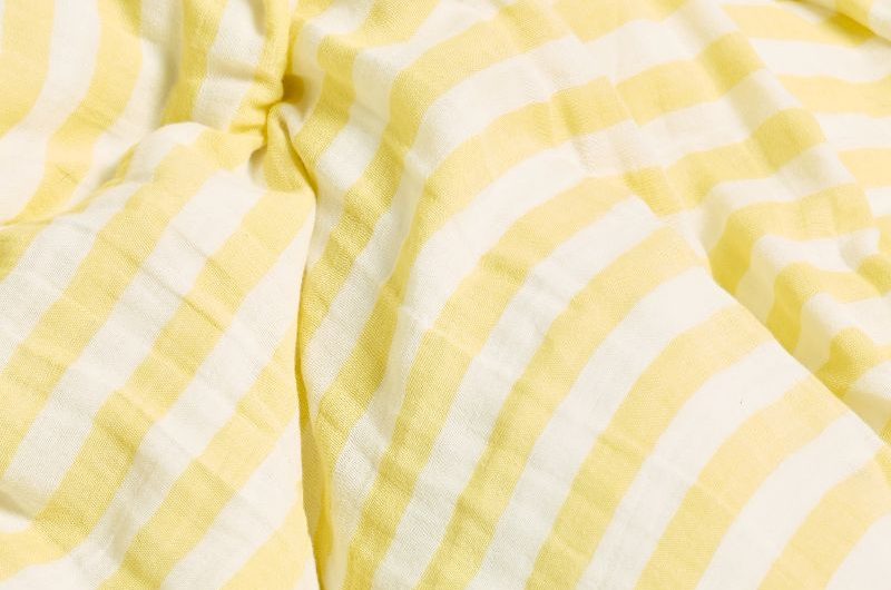 Closeup at a yellow and white striped bed linen set.