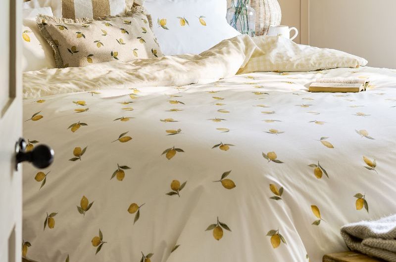 A sunny bedroom with lemon-patterned linen and dainty decor.