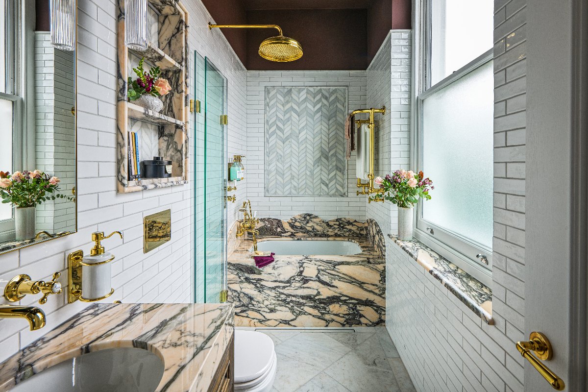 A luxury ensuite with metro tiles, marble leaf mosaic, pink marble bath surround and matching oak vanity.
