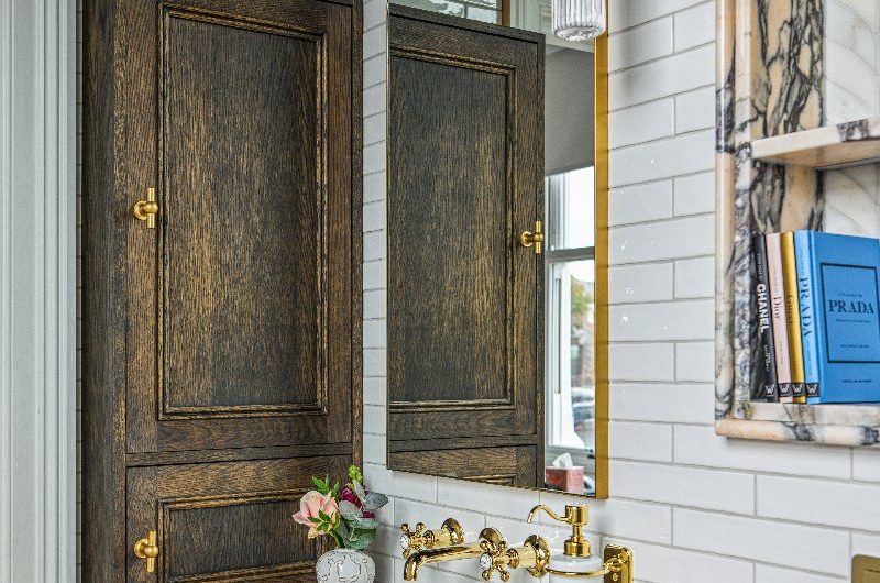 A guest ensuite with luxurious pink marble on the wood vanity, long slim metro tiles, and gold fittings.