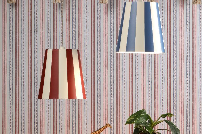 Closeup at a striped wallpaper with striped pendants, wood side table, and quirky decor.