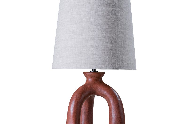 A unique lamp base in red with a linen shade.
