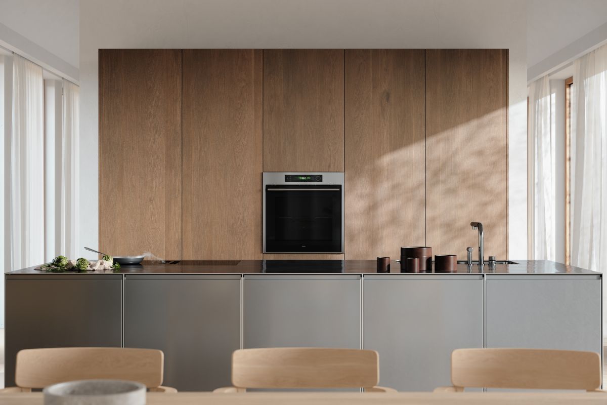 A sleek cooking zone with tall floor-to-ceiling cupboards and a metallic island.