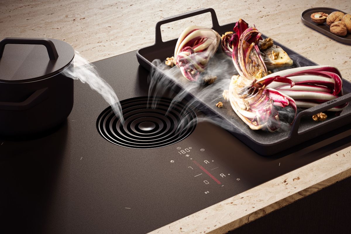 A matt extractor hob on an island with travertine marble.