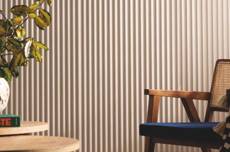 A calm living room with tactile wall panelling and wooden furniture.