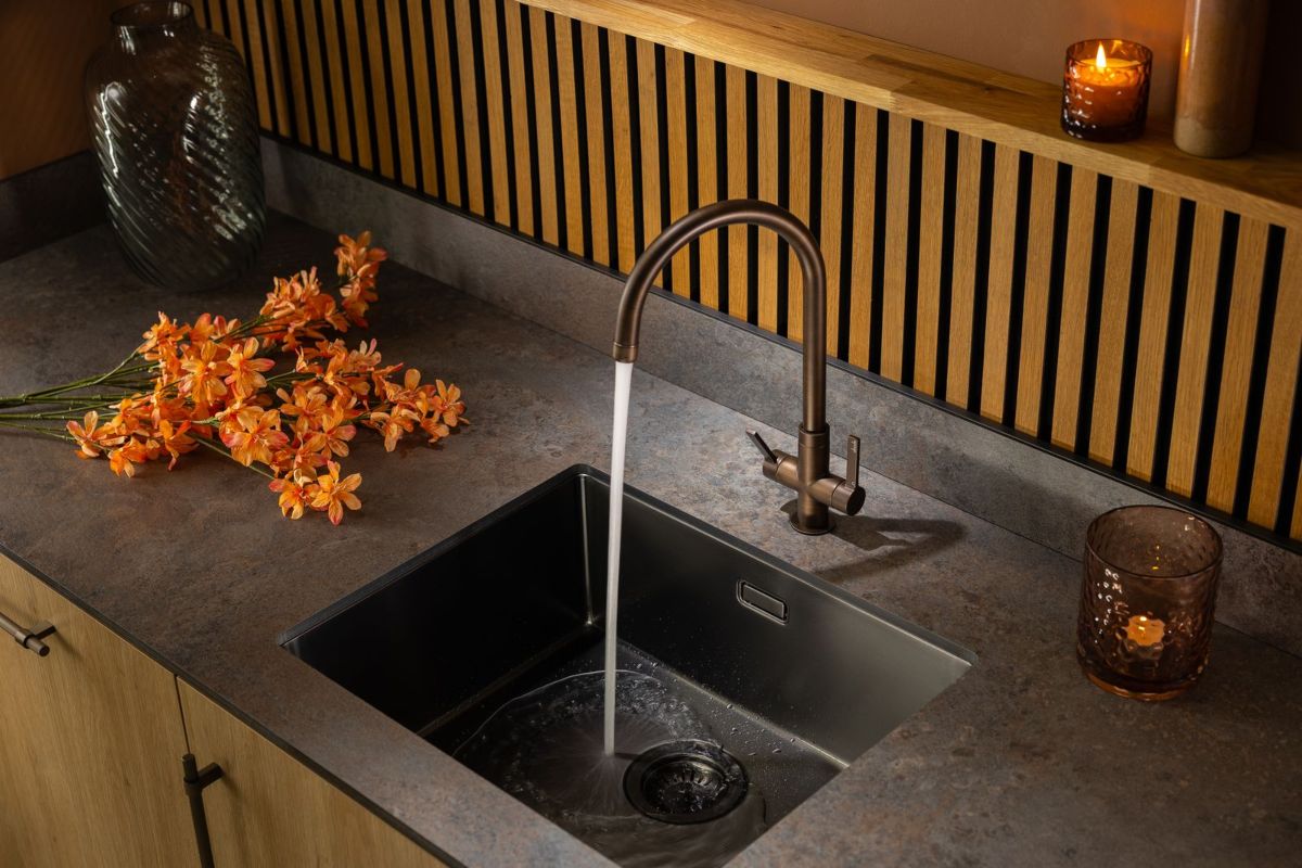 A kitchen design with an industrial feel, inset sink and tap, and fluted panelling.