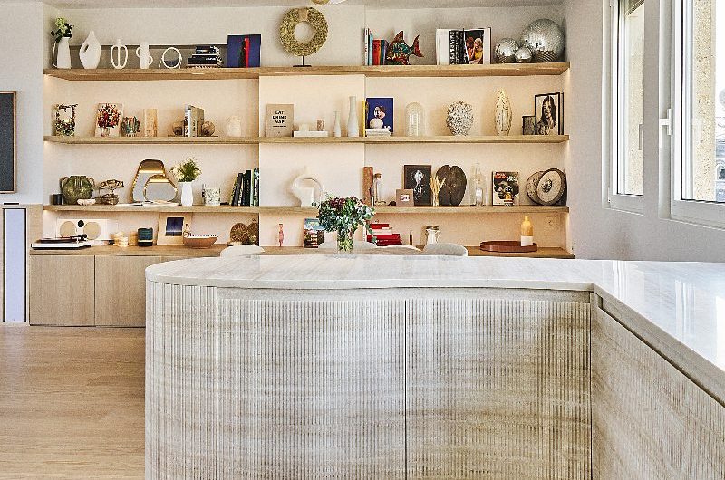 A fluted peninsula with storage with open shelving in the background.