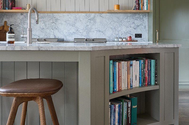 A curved island with seating and handy storage for cookery books.