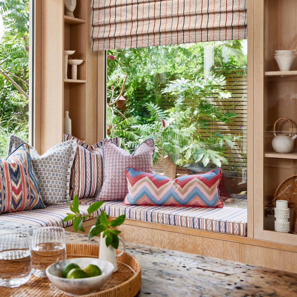 A spring summer textile collection in a snug with wood furniture, and wide windows.