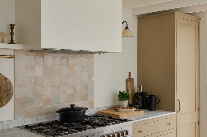 A cooking area with a stainless-steel range cooker, zellige splashback tiles, a concealed extractor, and marbled surfaces.