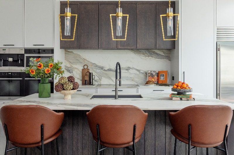 A modern kitchen with slim Shaker cabinets, a wood and stone-effect island with seating, and mixed finishes in a London home.