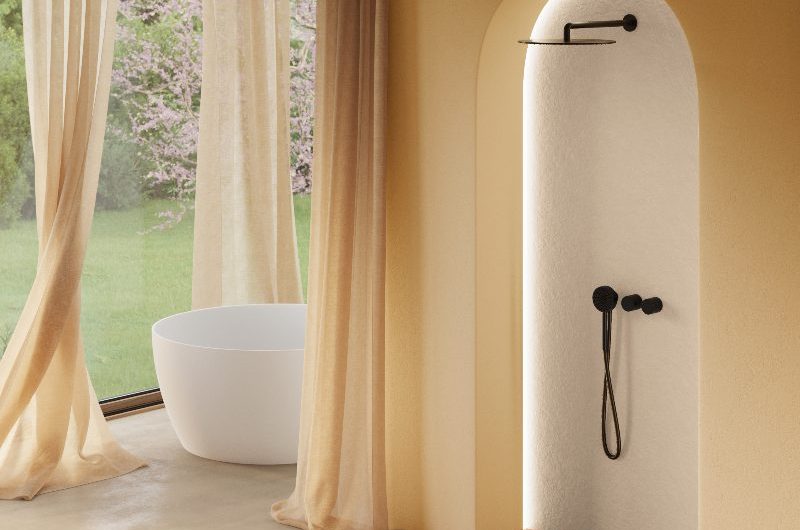 A spa like bathroom with textured shower panel and orange tray, black brassware, airy curtains, and neutral wall and floor coverings.