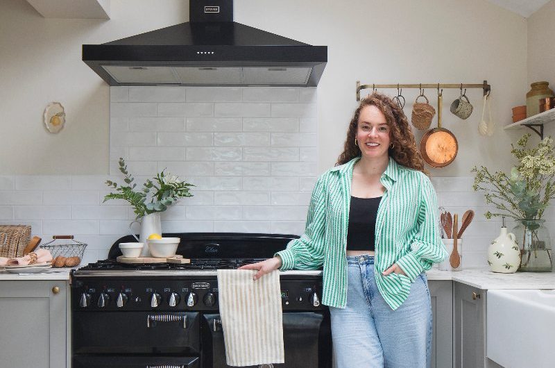 Homeowner posing in her renovated kitchen with her dog.