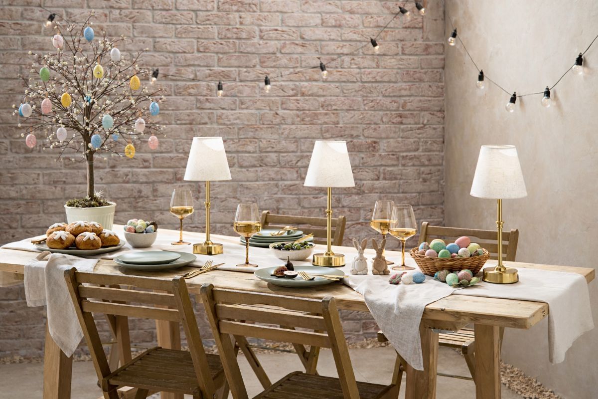 A simple Easter table with wine glasses, neutral table linen, and rechargeable table lamps.