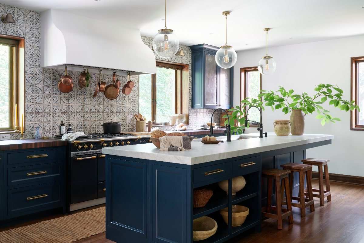 An American kitchen design with dark wood floors, dark blue cabinets, and a central island.