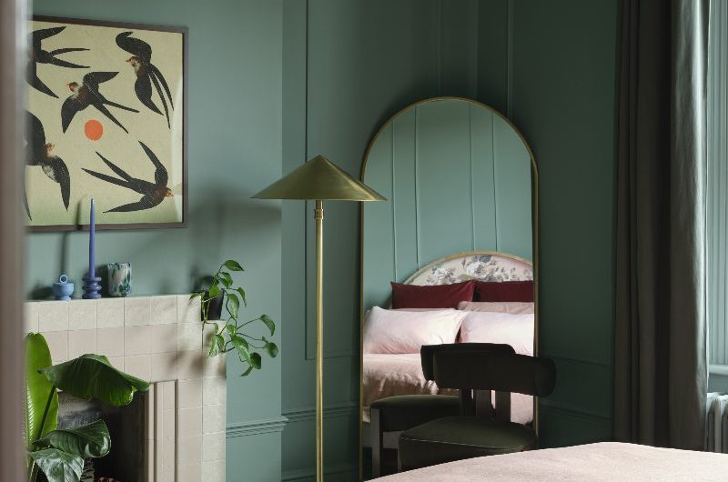A green drenched bedroom with luxurious furnishings and decor.