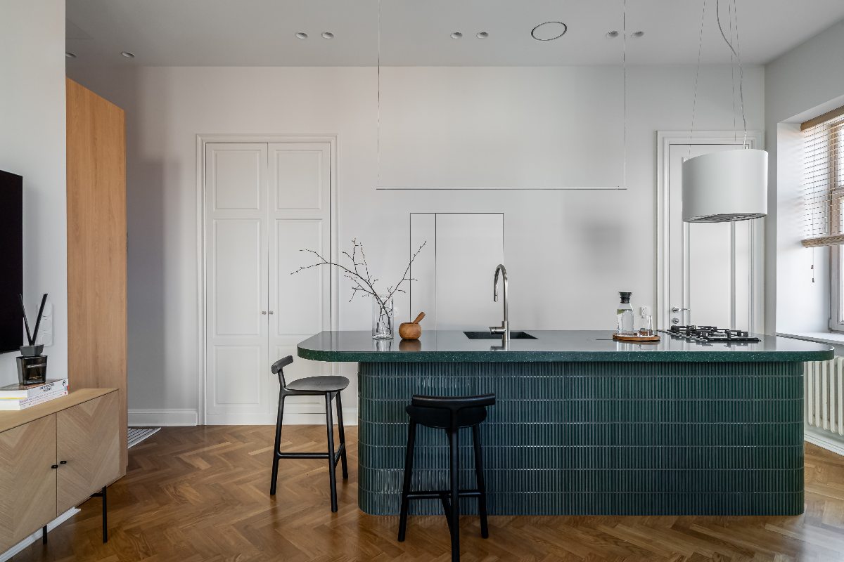 A Lithuanian kitchen design with a green island and concealed fridge.