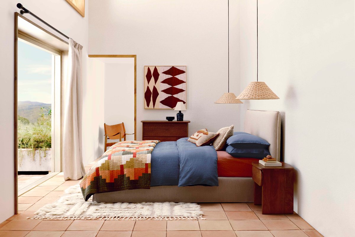 A mi-century sleep space with geometric shapes, earthy colourways, and wood furniture.