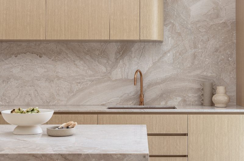 Closeup at the blonde oak kitchen design with sandy marble and a tactile island.