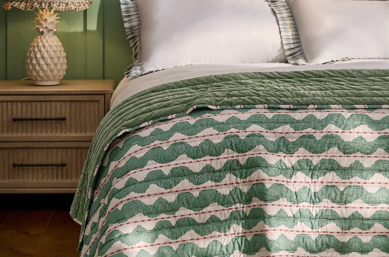 A modern twee bedroom design with playful patterns, wood furniture, and a palette of calming greens.