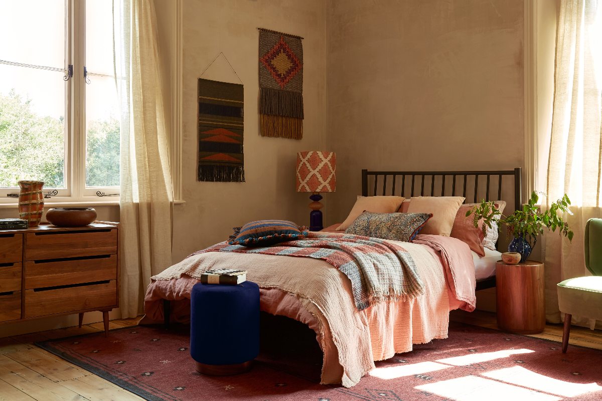A mid-century bedroom with earthy colourways, layered textiles and geometric patterns.