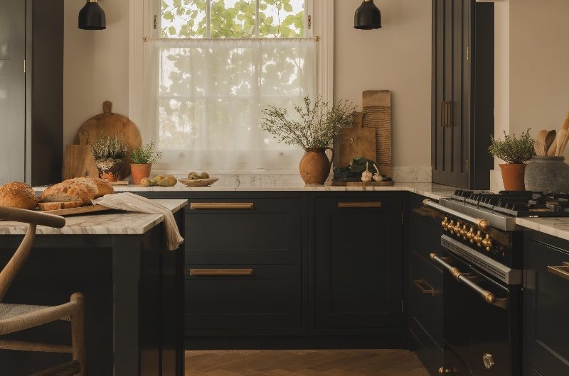 An L-shaped kitchen layout with black cabinets and a central island.