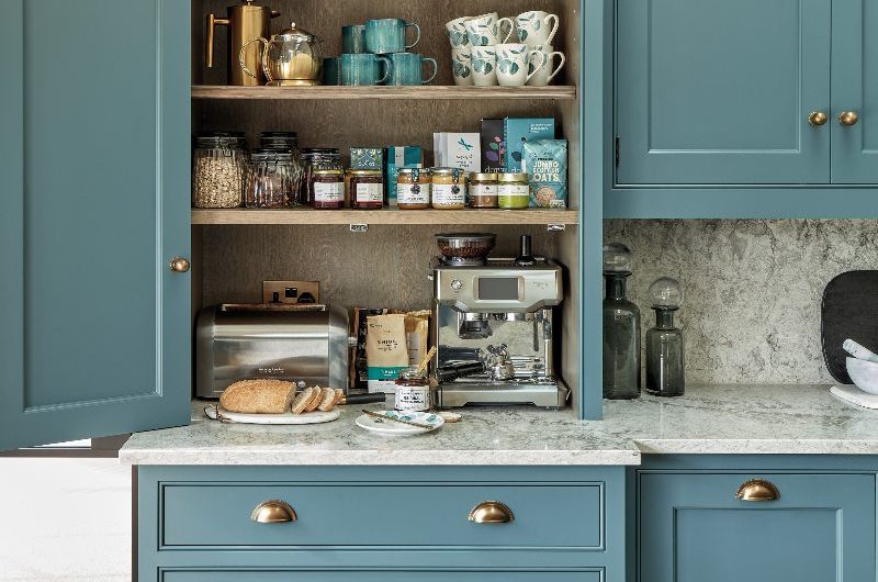 A calm blue kitchen with veiny surfaces, oak interiors, and a coffee zone.