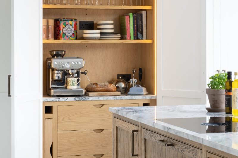 A classic kitchen with white Shaker units, oak interiors, and a central island.
