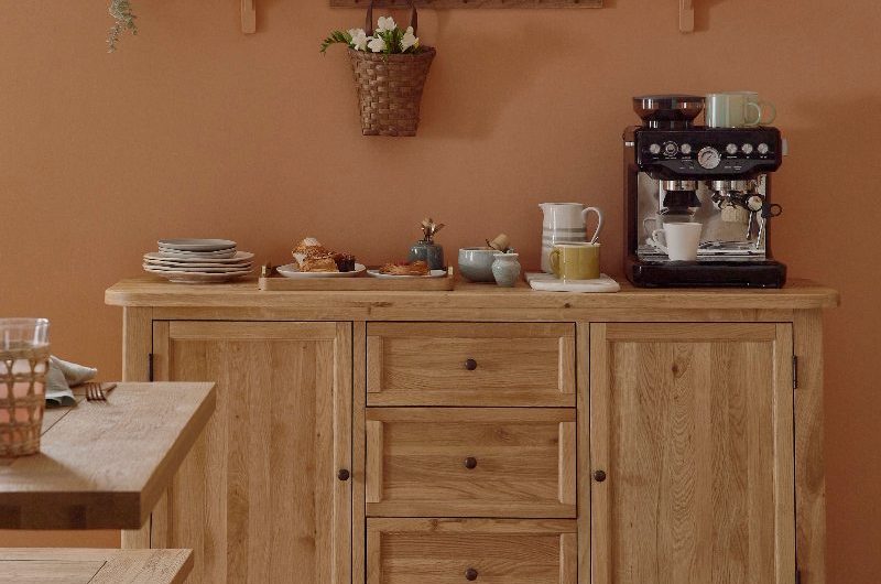 A coffee station with an oak dresser, and open shelving.