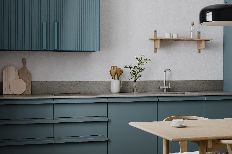 Blue cabinetry with matching pull handles, concrete-effect worktops and fluted wall cabinets.