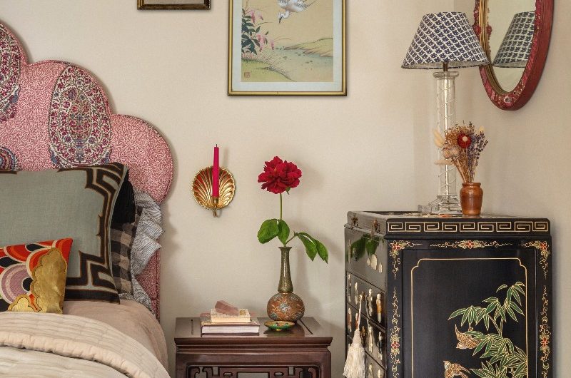 Neutral bedroom with old chinoiserie cabinet  next to it.