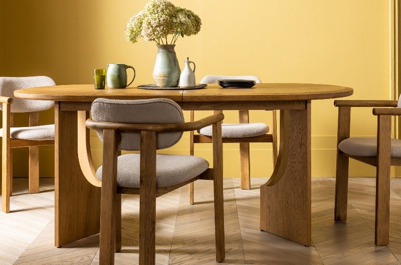 Colour drenched dining room in yellow with a wood table and chair set.