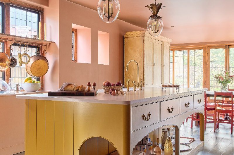 Yellow multi-functional kitchen island design with drawers, sink and tap, and shelf for storage.