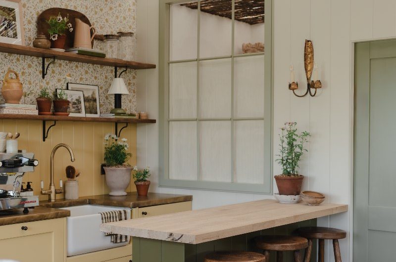 Farmhouse-inspired design with wood worktops, checkerboard flooring, and floral wallpaper.