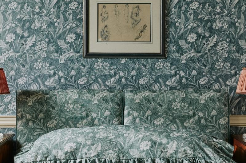 Pattern drenched bedroom with green and floral printed fabrics and coverings.