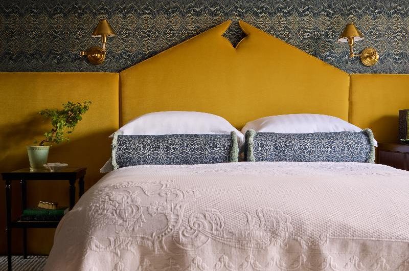 Marrakech-influenced bedroom trend with a statement headboard, patterned wallcoverings and neutral linen.