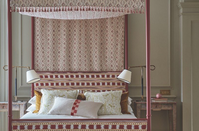 Classic bedroom with a patterned bed frame, jute rug, and vintage side tables.