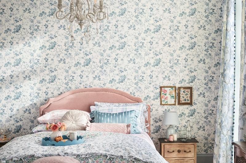 Fairytale scheme with floral wallpaper and bedding in soft, feminine shades.