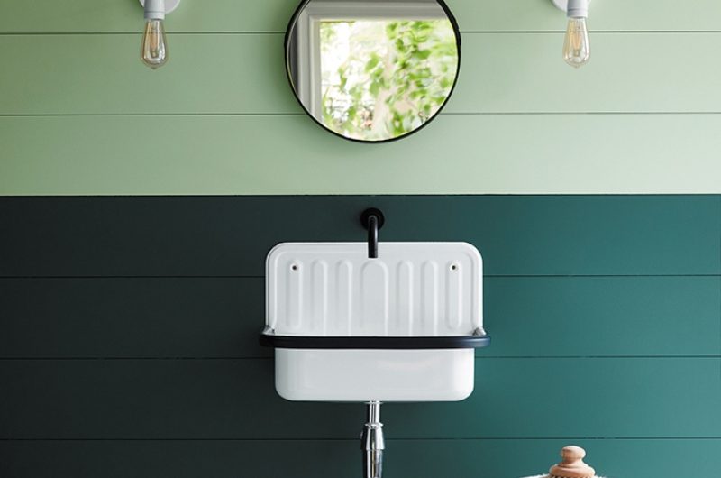 Bathroom washing up zone with green paint on the wall panelling, a classic basin, and a stool for accessories and toiletries.