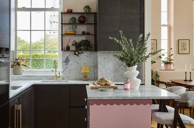 Dark handleless kitchen design with a bespoke, scallop-edged island on castors.
