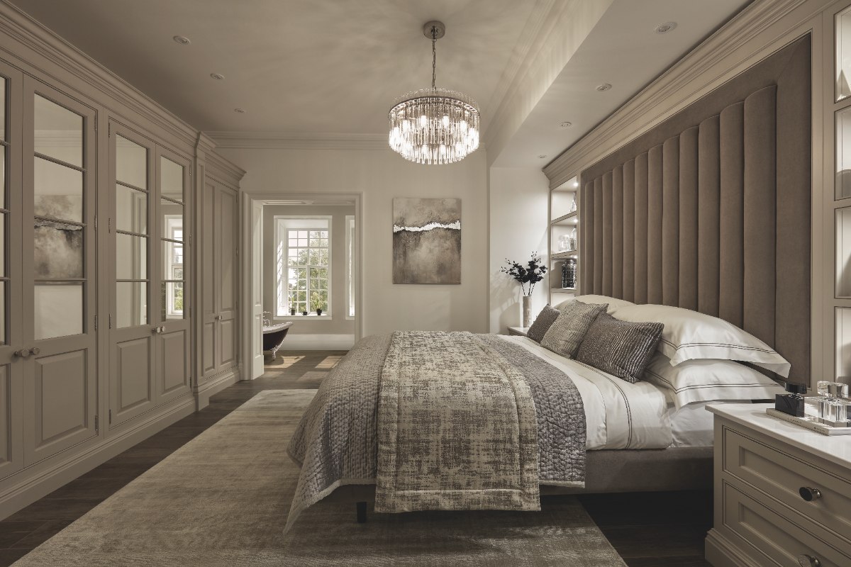 A luxury bedroom with neutral finishes, quality furniture and chandelier light.