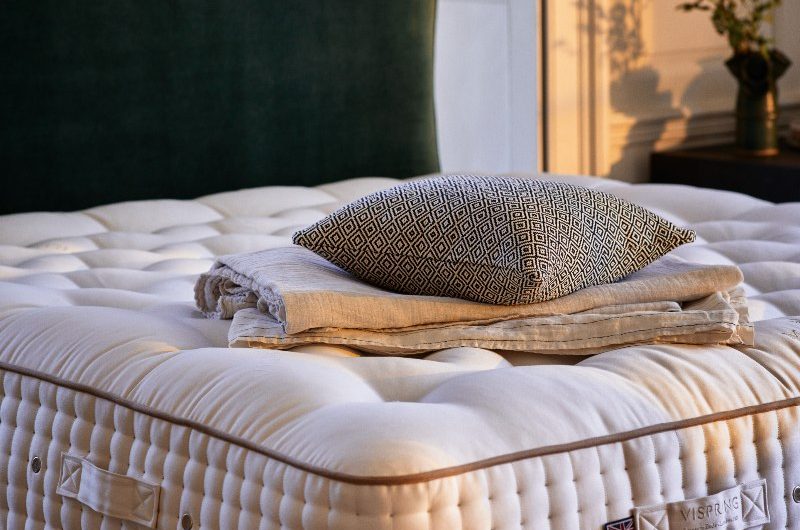 A green velvet frame with a luxury mattress.