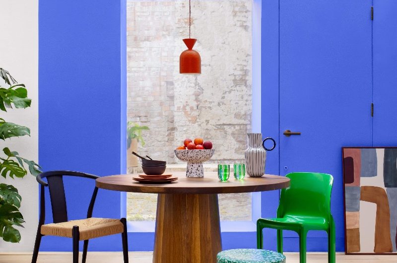 Dining area drenched in a blue shade with green accents.