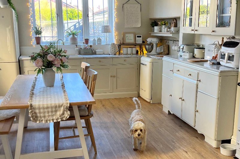 A warm and welcoming renovation with wood flooring and cream cabinetry.