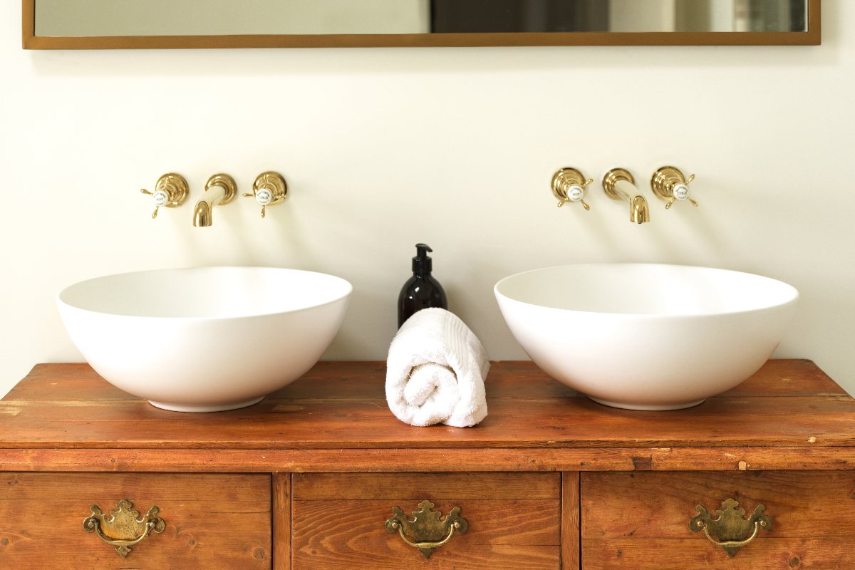 Close-up at the white basins sitting on top of a vintage vanity.